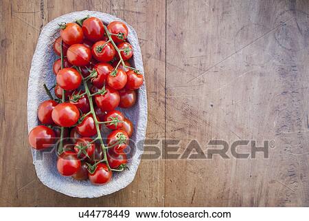 Still life of cherry vine tomatoes in cardboard container View Large Photo Image Stock Photo - Still life of cherry vine tomatoes in cardboard container. Fotosearch