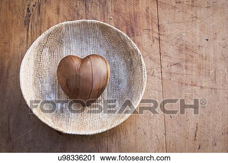 Still life of heart shaped wooden object in wooden bowl View Large Photo Image Stock Image - Still life of heart shaped wooden object in wooden bowl. Fotosearch