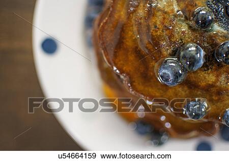 Still life overhead view of blueberry pancakes with maple syrup View Large Photo Image Stock Photo - Still life overhead view of blueberry pancakes with maple syrup. Fotosearch