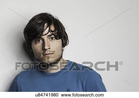 Studio portrait of young man in blue tshirt View Large Photo Image Stock Image - Studio portrait of young man in blue tshirt. Fotosearch