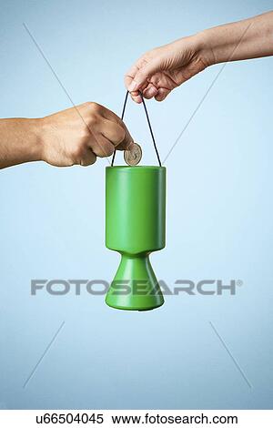 Studio shot of hand putting coin into charity collection box View Large Photo Image Stock Photography - Studio shot of hand putting coin into charity collection box. Fotosearch
