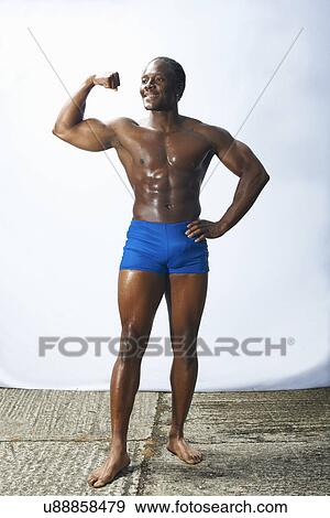Stock Photo - Studio shot of male bodybuilder flexing muscles. Fotosearch