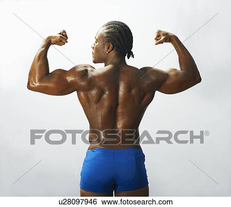 Stock Photograph - Studio shot of male bodybuilder flexing pectoral muscles. Fotosearch
