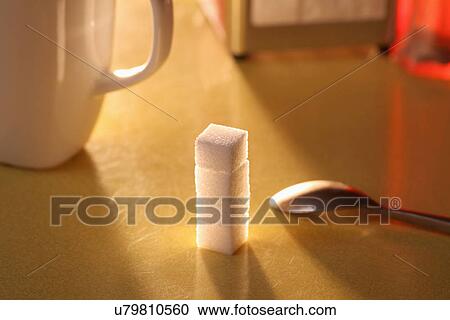 Stock Image - Sugar lumps stacked on table. Fotosearch