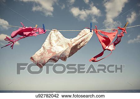 Swimwear hanging on coastal washing line View Large Photo Image Stock Image - Swimwear hanging on coastal washing line. Fotosearch