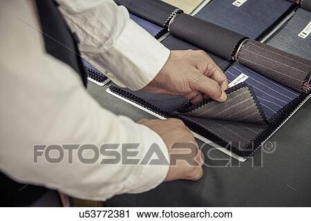 Tailor choosing fabric from swatch in tailors shop View Large Photo Image Stock Image - Tailor choosing fabric from swatch in tailors shop. Fotosearch