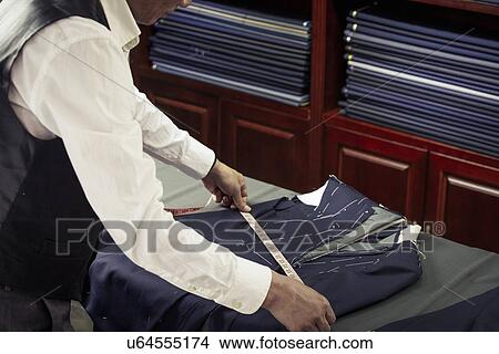 Tailor measuring garment in tailors shop View Large Photo Image Picture - Tailor measuring garment in tailors shop. Fotosearch
