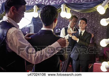 Tailor with young male client trying on new suit in traditional shop View Large Photo Image Stock Photograph - Tailor with young male client trying on new suit in traditional shop. Fotosearch