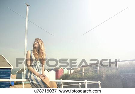 Stock Photo - Teenage girl, beach huts in background, Southwold, Suffolk, UK. Fotosearch