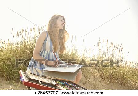 Stock Photo - Teenage girl drawing on the beach. Fotosearch