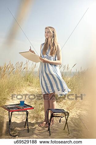 Teenage girl drawing on the beach View Large Photo Image Stock Photo - Teenage girl drawing on the beach. Fotosearch