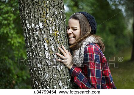 Teenage girl leaning on tree in forest View Large Photo Image Picture - Teenage girl leaning on tree in forest. Fotosearch