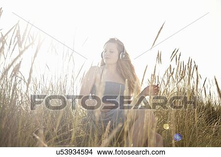 Teenage girl listening to music outdoors View Large Photo Image Picture - Teenage girl listening to music outdoors. Fotosearch
