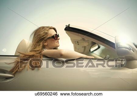 Teenage girl showing off in sports convertible View Large Photo Image Stock Photograph - Teenage girl showing off in sports convertible. Fotosearch