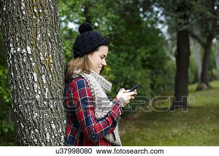 Teenage girl using cellular phone in forest View Large Photo Image Stock Image - Teenage girl using cellular phone in forest. Fotosearch