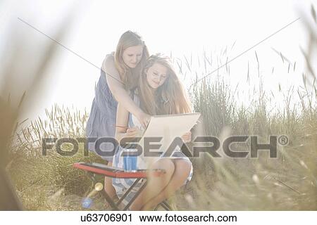 Stock Image - Teenage girls drawing on the beach. Fotosearch