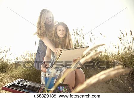 Teenage girls drawing on the beach View Large Photo Image Stock Photography - Teenage girls drawing on the beach. Fotosearch