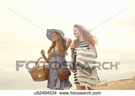 Teenage girls walking on beach with picnic basket View Large Photo Image Picture - Teenage girls walking on beach with picnic basket. Fotosearch