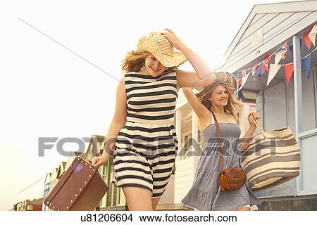 Teenage girls walking past beach huts View Large Photo Image Picture - Teenage girls walking past beach huts. Fotosearch
