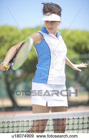 Stock Photo - Tennis player hitting backhand volley. Fotosearch