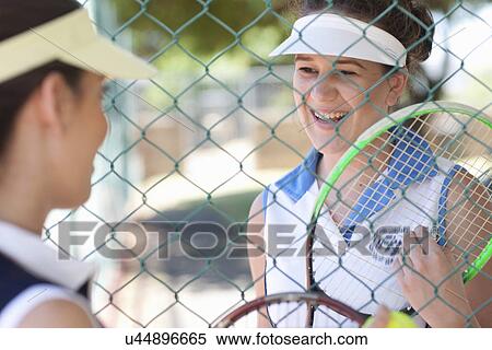 Stock Photography - Tennis players talking at the fence. Fotosearch