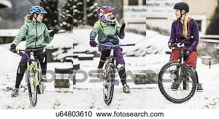 Stock Image - Three female mountain bikers on bikes and chatting. Fotosearch