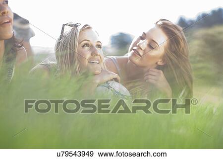 Three friends lying in grass daydreaming View Large Photo Image Stock Photo - Three friends lying in grass daydreaming. Fotosearch