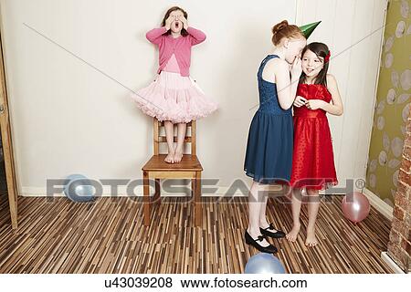 Three girls playing hide and seek at birthday party View Large Photo Image Stock Photo - Three girls playing hide and seek at birthday party. Fotosearch