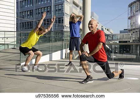 Three male athletes exercising on city rooftop View Large Photo Image Stock Photograph - Three male athletes exercising on city rooftop. Fotosearch
