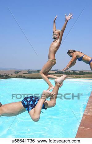 Stock Photograph - Three people jumping into swimming pool. Fotosearch