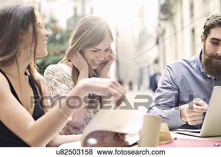 Three tourist friends enjoying a break at sidewalk cafe, Valencia, Spain View Large Photo Image Stock Photo - Three tourist friends enjoying a break at sidewalk cafe, Valencia, Spain. Fotosearch