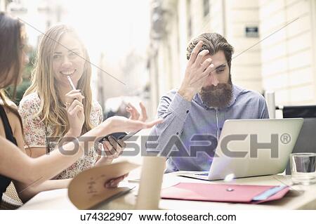 Stock Photo - Three tourist friends taking a break at sidewalk cafe, Valencia, Spain. Fotosearch