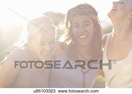 Three young female friends laughing View Large Photo Image Stock Image - Three young female friends laughing. Fotosearch