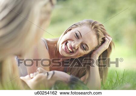 Three young females friends lying in grass View Large Photo Image Stock Image - Three young females friends lying in grass. Fotosearch