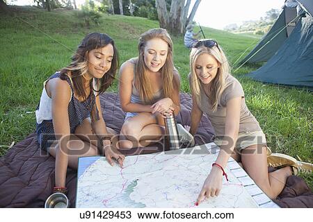 Three young females friends planning route whilst camping View Large Photo Image Stock Image - Three young females friends planning route whilst camping. Fotosearch