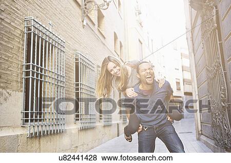 Stock Photo - Tourist couple giving piggy back ride, Valencia, Spain. Fotosearch