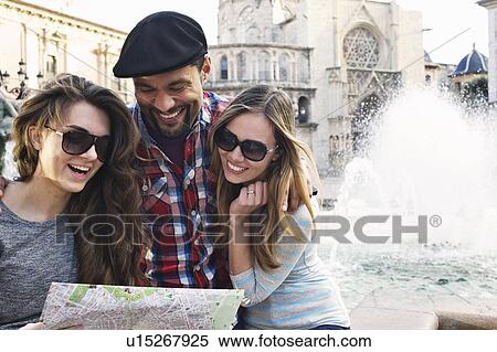 Tourist friends looking at map, Plaza de la Virgen, Valencia, Spain View Large Photo Image Stock Photography - Tourist friends looking at map, Plaza de la Virgen, Valencia, Spain. Fotosearch