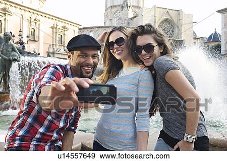 Stock Photo - Tourist friends taking self portrait, Plaza de la Virgen, Valencia, Spain. Fotosearch