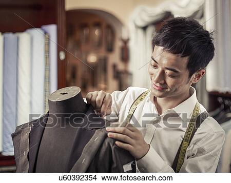 Trainee tailor pinning garment in traditional tailors shop View Large Photo Image Picture - Trainee tailor pinning garment in traditional tailors shop. Fotosearch