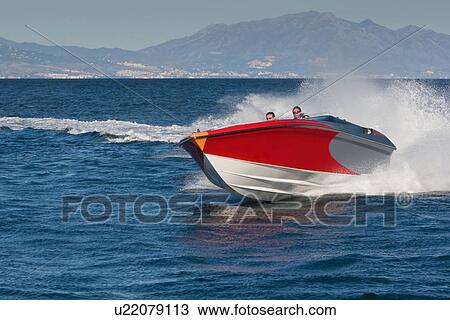 Stock Image - Two adult men having fun in speedboat, Sotogrande, Cadiz, Spain. Fotosearch