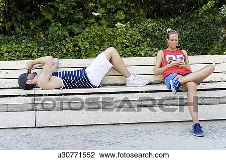 Two basketball players taking a break on park bench View Large Photo Image Stock Image - Two basketball players taking a break on park bench. Fotosearch