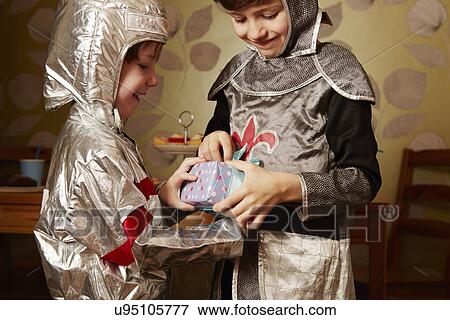 Two boys dressed as knights, one receiving birthday present View Large Photo Image Stock Photo - Two boys dressed as knights, one receiving birthday present. Fotosearch