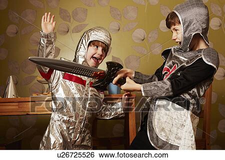 Two boys dressed as knights playing with toy sword View Large Photo Image Stock Photograph - Two boys dressed as knights playing with toy sword. Fotosearch