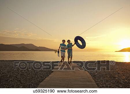 Stock Image - Two brothers running on boardwalk, Fethiye, Turkey. Fotosearch