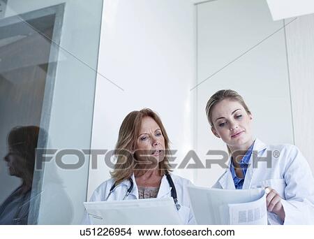 Picture - Two female doctors looking at medical notes. Fotosearch