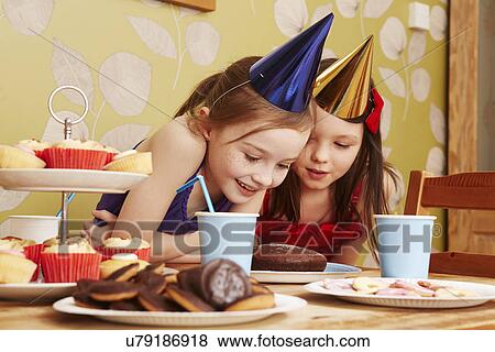 Two girls looking at cake View Large Photo Image Stock Photo - Two girls looking at cake. Fotosearch