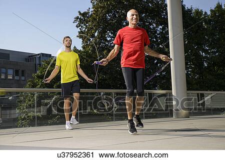Two male athletes training with skipping ropes View Large Photo Image Stock Image - Two male athletes training with skipping ropes. Fotosearch