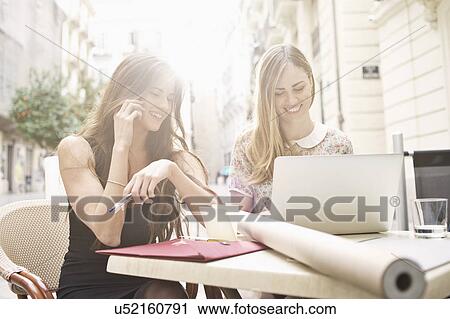 Two young female friends taking a break at sidewalk cafe, Valencia, Spain View Large Photo Image Stock Image - Two young female friends taking a break at sidewalk cafe, Valencia, Spain. Fotosearch