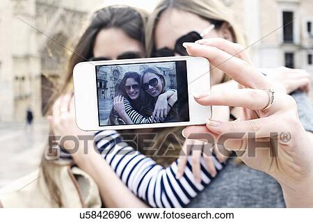 Two young female friends taking a self portrait, Valencia, Spain View Large Photo Image Stock Photograph - Two young female friends taking a self portrait, Valencia, Spain. Fotosearch