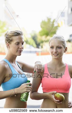 Stock Photo - Two young female runners taking a break. Fotosearch